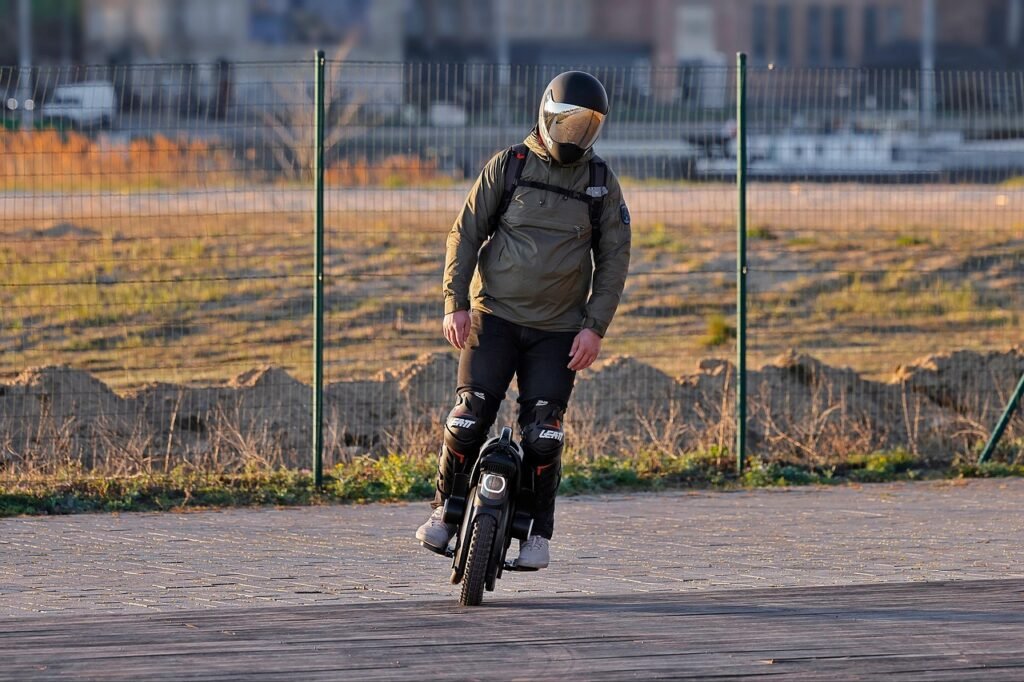 Young man riding on his Electric Unicycle Young man riding on his Electric Unicycle and wearing helmet