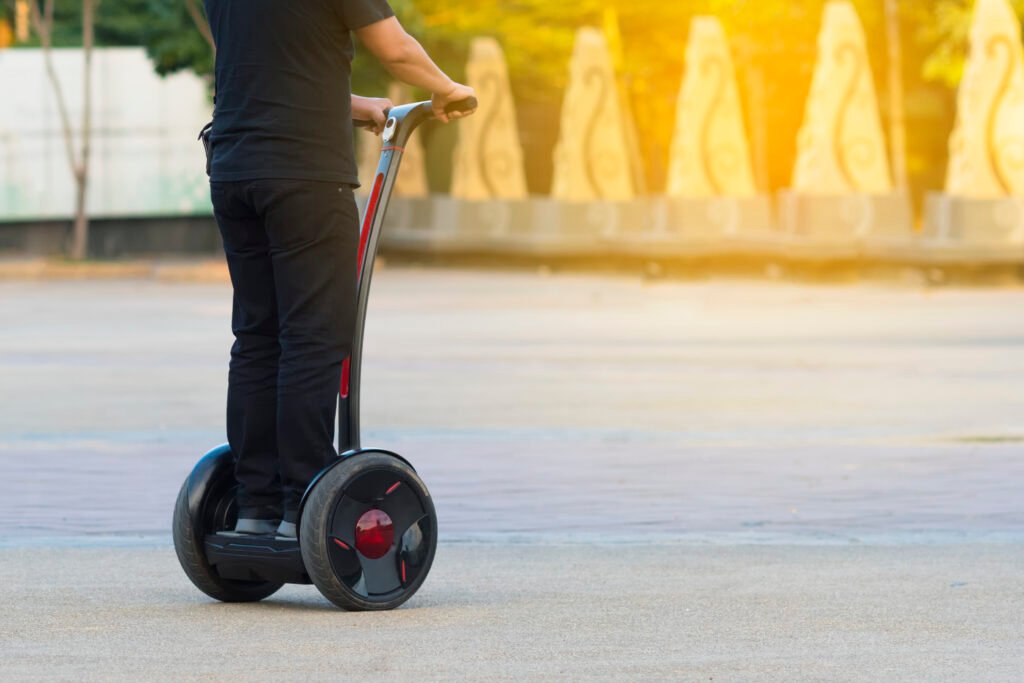 Closeup of a boy riding on his handlebar hoverboard in the city