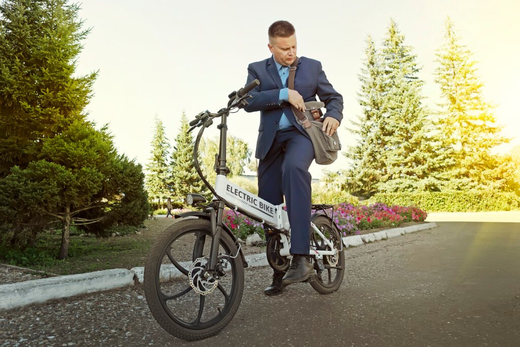 businessman commuter with electric bicycle traveling to work in city