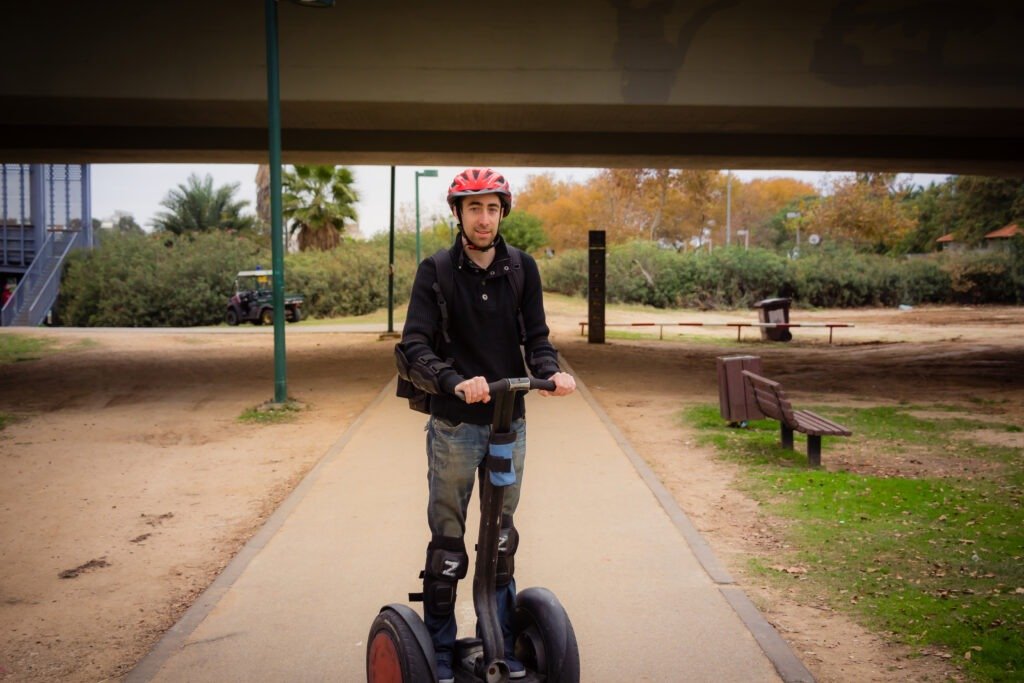 Man riding safely on a hoverboard in the park.