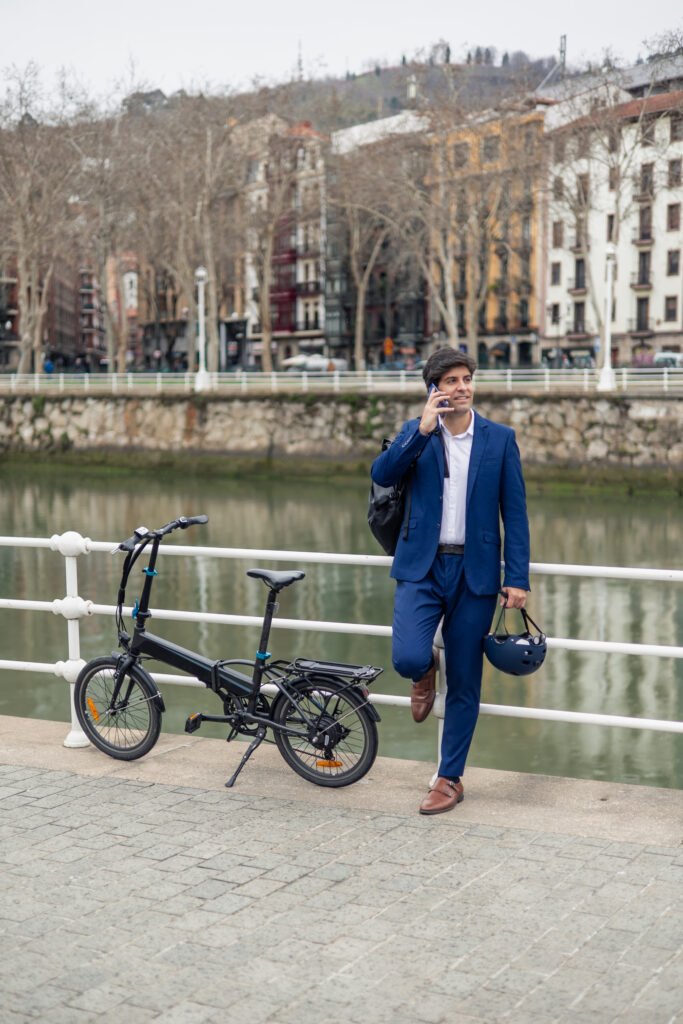 Foldable e-bike vertical portrait Businessman Embracing Sustainable Mobility: Using Electric Bike for Urban Commute