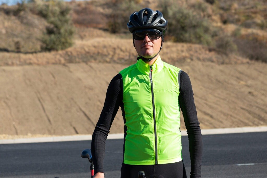 Cyclist wearing reflective clothing riding e-bike on road Cyclist wearing reflective clothing riding e-bike on road