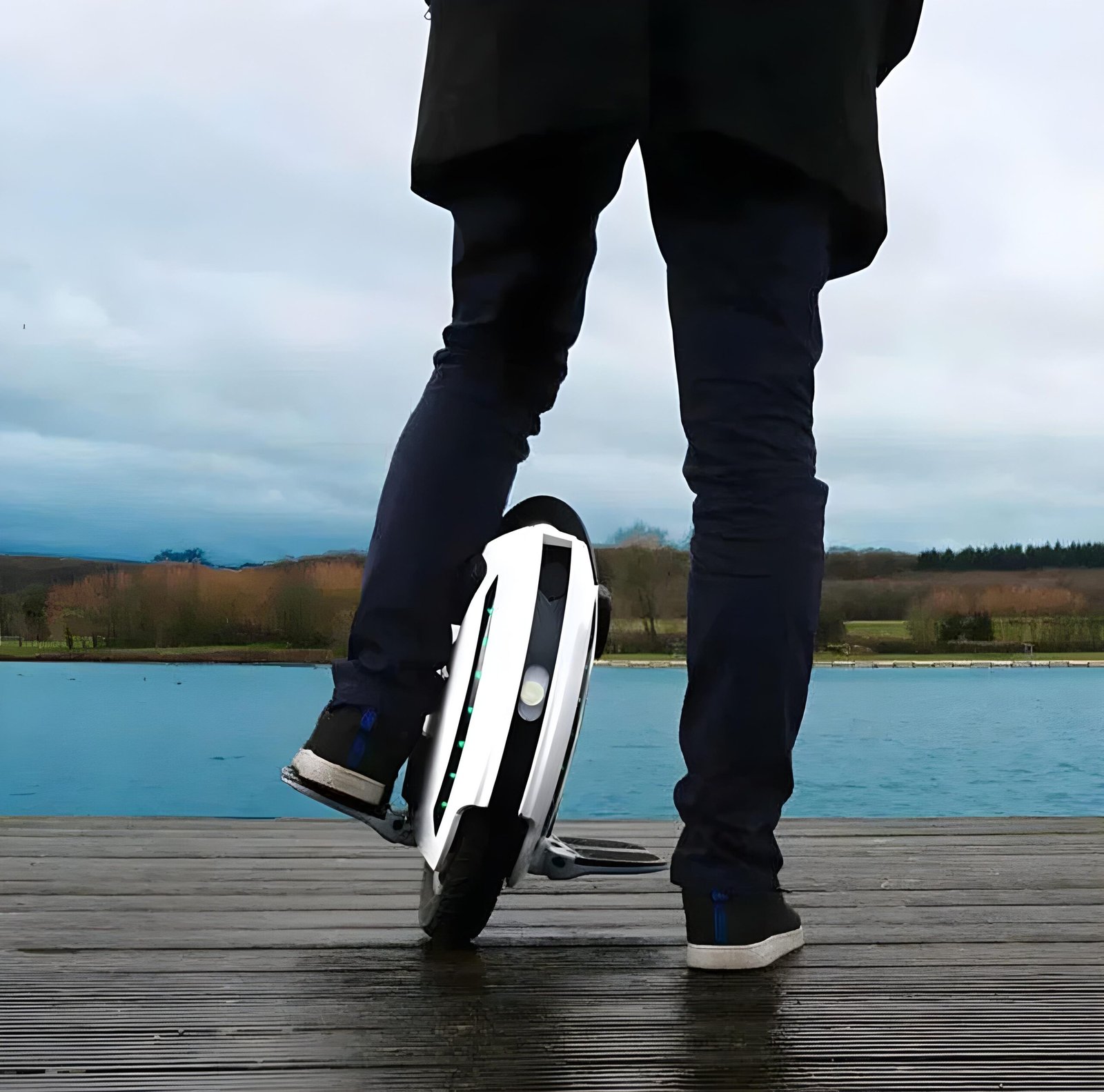 KingSong 14D electric unicycle Man riding KingSong 14D electric unicycle near a lake, featuring a compact design and 800W motor