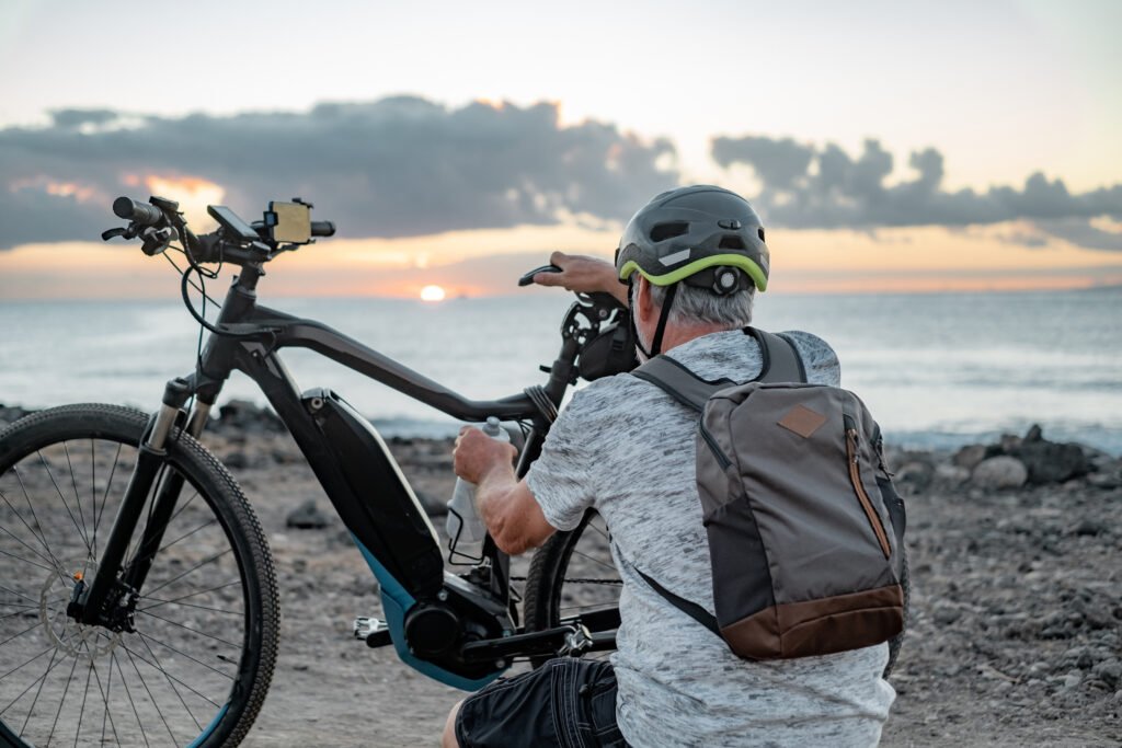 Rear view of active caucasian senior man with electric bicycle Rear view of active senior man with electric bicycle