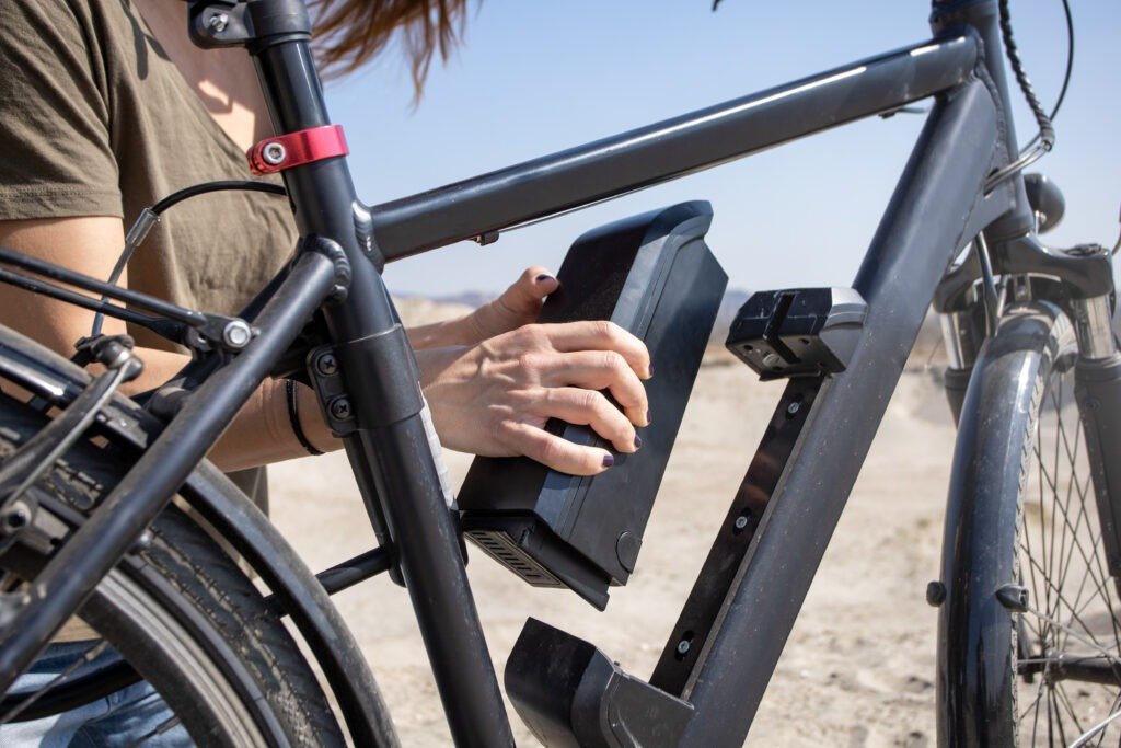 Woman removes electric bike battery from frame