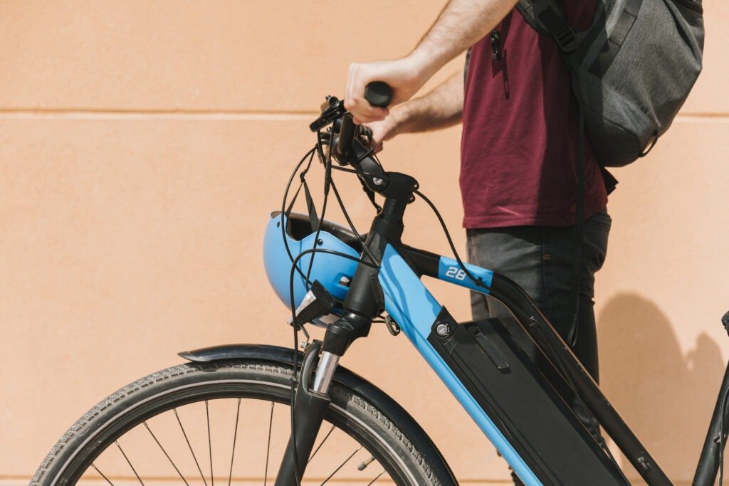 Cyclist standing next to his e-bike